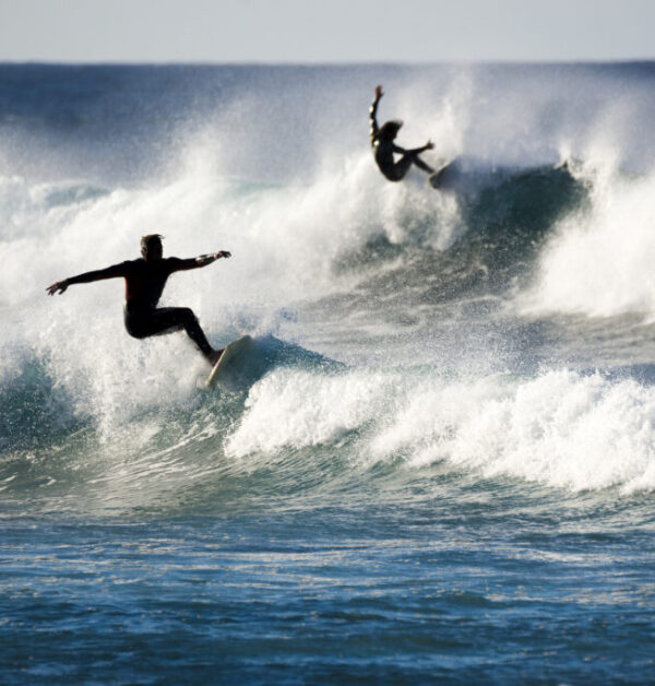 two surfers in action on the waves by InsiderFuerteventura