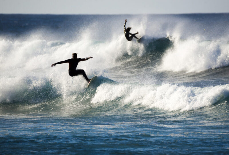 two surfers in action on the waves by InsiderFuerteventura